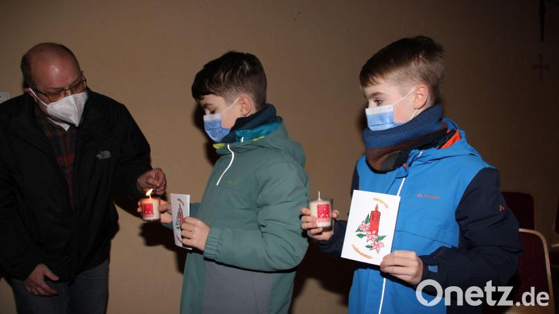 Der Gemeindereferent von Hl. Dreifaltigkeit, Anton Rauch, übergibt an die Firmlinge Fabian und Kilian (von links) wie an die anderen 18 Firmlinge der Pfarrei auch das Friedenslicht, das sie Menschen ihrer Wahl überbringen dürfen, um diesen eine kleine Vorweihnachtsfreude zu bereiten. Bild: ads