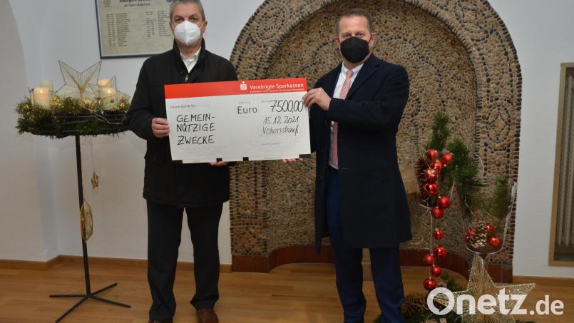 Vorstandsvorsitzender Gerhard Hösl von der Vereinigten Sparkasse (rechts) übergibt an Bürgermeister Andreas Wutzlhofer (links) einen Spendenscheck in Höhe von 7500 Euro für verschiedene Bildungseinrichtungen. Bild: doj