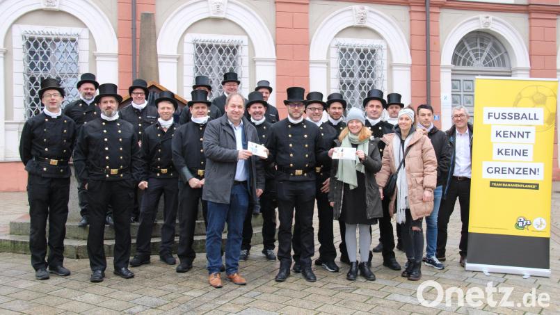 15 Kaminkehrermeister in ihren Gala-Uniformen mit Zylinder und weißem Schal sieht man nicht alle Tage. Stellvertretend für 27 Spender übergab Manuel Schätzler (vorne, Mitte) insgesamt 5400 Euro Spende an Carina Völkl (vorne, Zweite von rechts) vom Team Bananenflanke Nordoberpfalz und Holger Hassel (vorne links), Leiter des SOS-Kinderdorfs Oberpfalz. Bild: prh