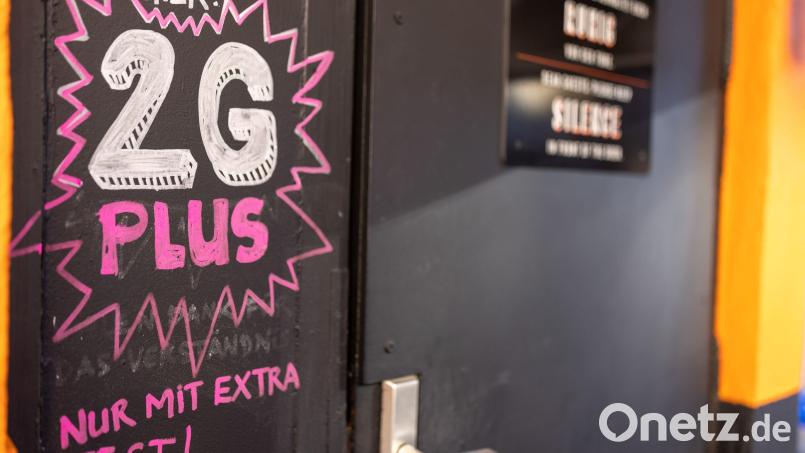 Hinweis auf 2G plus bei einer Bar in der Nürnberger Innenstadt. Symbolbild: Daniel Karmann/dpa