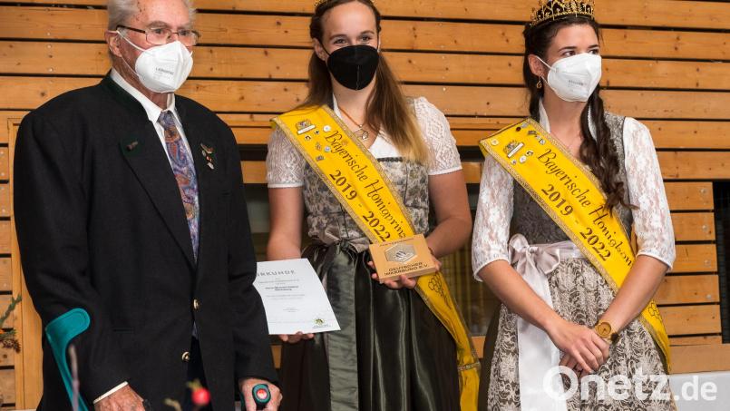 Bienenzuchtvereinsehrenvorsitzender Michael Hüttner bei der Ehrung mit Honigkönigin Katharina II. (rechts) und Honigprinzessin Alexandra. Bild: (C)STK/LVBI