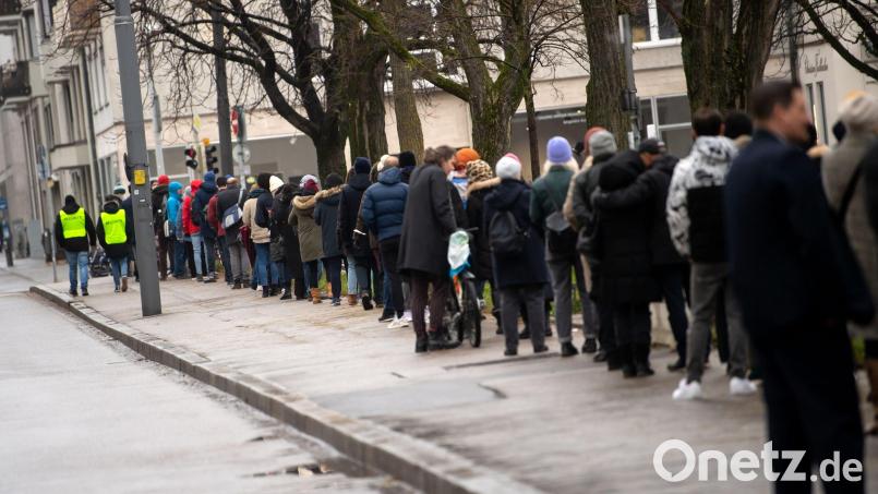 Menschen stehen vor einem Corona-Impfzentrum in München Schlange. Bild: Sven Hoppe/dpa