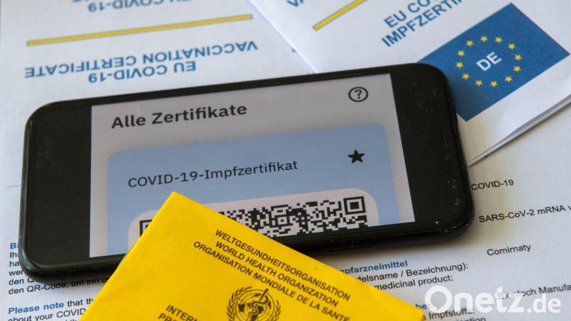 Ein Impfpass und ein Smartphone mit der CovPass-App liegen auf einem Impfzertifikat. Foto: Stefan Puchner/dpa/Symbolbild Symbolbild: Stefan Puchner