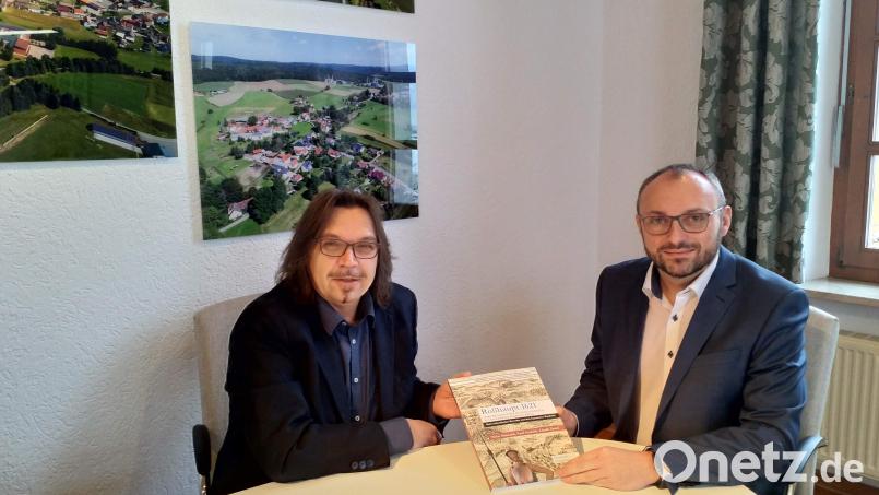 Ortsheimatpfleger Andreas Ringholz (links) übergibt eines der ersten Exemplare des neuesten Waidhauser Druckwerks an Bürgermeister Markus Bauriedl. Bild: fjo