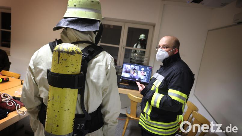 Feuerwehrmann Daniel Messmang (rechst) präsentiert virtuell zugeschalteten Schulungsteilnehmern in der Feuerwache Sonthofen einen Feuerwehrmann mit Schutzkleidung und Atemschutz. Archivbild: Karl-Josef Hildenbrand