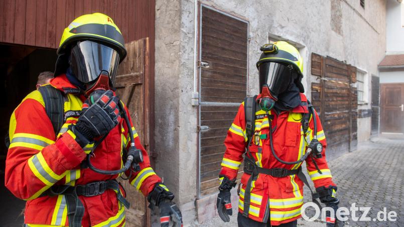 Zwei Feuerwehrmänner stehen in voller Einsatzmontur vor einem früheren Kuhstall. Da wegen des Coronavirus derzeit keine Atemschutzausbildung stattfinden kann, bauten Feurwehrleute in einen früheren Kuhstall einen Hindernisparcours. Archivbild: Stefan Puchner