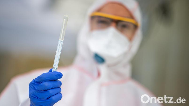 Ein Mitarbeiter hält in einem Abstrichzentrum einen Coronatest-Abstrich in der Hand. Symbolbild: Sebastian Gollnow/dpa