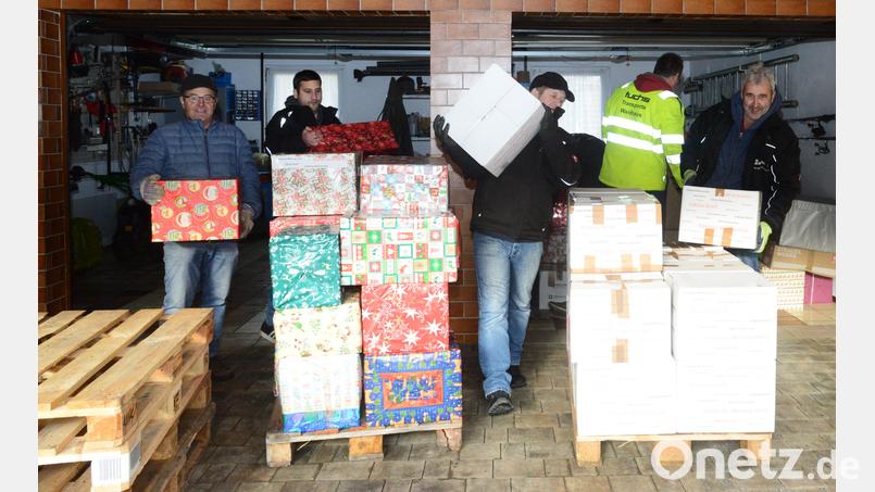 Von der Garage als vorübergehendem Lagerplatz auf die Paletten werden die 195 Pakete umgeschlichtet, dann werden die Paletten auf den Lkw gehoben. Bruno Friedl (links) hat die Sammelaktion in der Großgemeinde Pleystein organisiert, Ludwig "Lucky" Wüst (rechts) macht das in der Gemeinde Georgenberg. Bild: bey