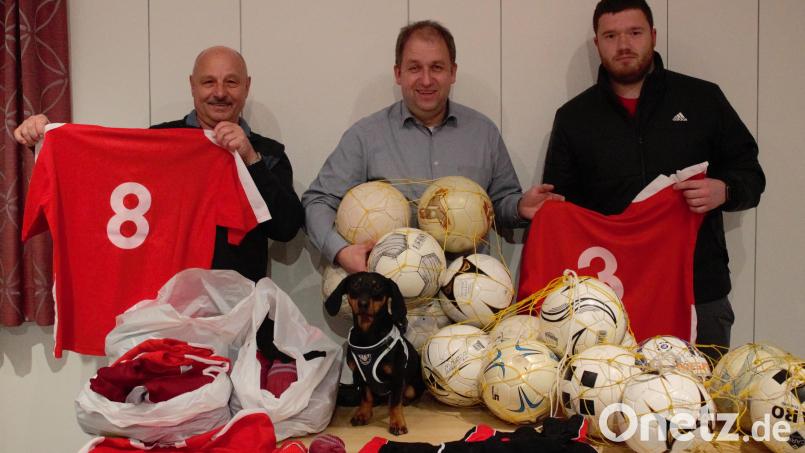 Zeug- und Platzwart Arno Zeitler (links) sowie Trainer Florian Schaumberger (rechts) vom ATS Mitterteich waren mit Maskottchen Sam (vorne) gekommen, um die Trikots und Bälle an Kinderdorfleiter Holger Hassel zu übergeben. Bild: ATS Mitterteich/exb