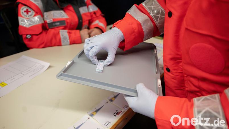 Eine ehrenamtliche DRK-Helferin nimmt in einer Teststation einen Corona-Schnelltest von einem Tablett. Symbolbild: Marijan Murat/exb