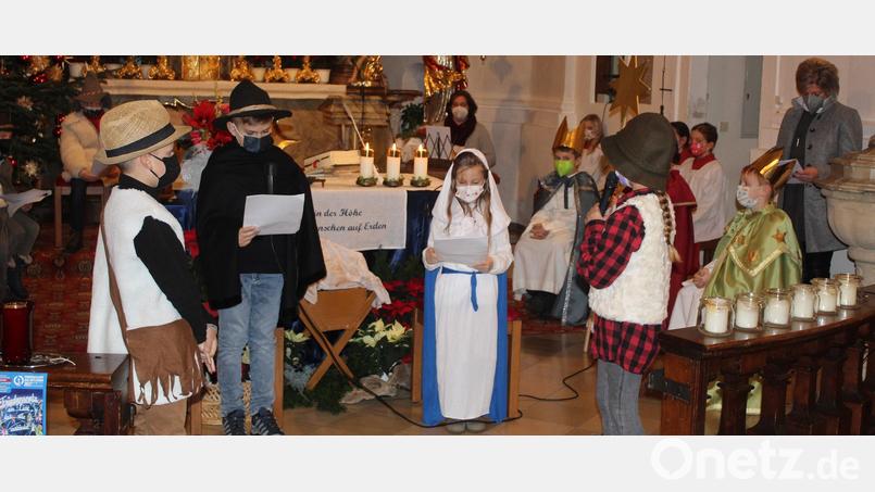 Maria und Josef, dargestellt von Alena Thoma und Bastian Matthes, mit dem Neugeborenen. Hirten bestaunen das Jesuskind. In der weihnachtlich geschmückten Kirche brachten die Buben und Mädchen vor dem erstrahlten Christbaum die Weihnachtsgeschichte zum Ausdruck. Bild: soj