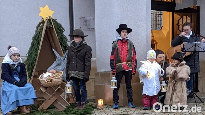 Kinder führen auf dem Kirchplatz in Ursulapoppenricht ein Krippenspiel auf (von links): Lena Götz als Maria, Puppe Mimi als Jesuskind, Esel Fridulin, Jakob Götz als Josef, Sebastian Koller als großer Hirte, Engel Jakob Körmer, der kleine Hirte Lukas Körmer (dazwischen Schauspielerbetreuer David Körmer) und Rita Butz (musikalische Begleitung). Bild: Nicole Koller