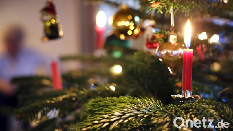 Kerzen brennen an einem festlich geschmückten Christbaum. Symbolbild: Karl-Josef Hildenbrand/dpa