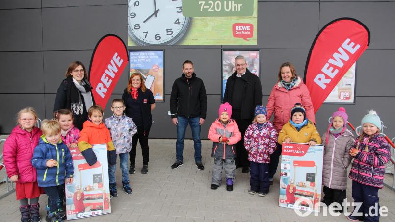 An freudestrahlende Kinder und deren Kindergartenleiterinnen Silke Pfab (St. Marien, links) und Julia Scheibl (St. Angelus, rechts), überreichten Rewe-Marktleiter Ferdinand Mihl (Bildmitte) und Marktmanagerin Anja Rehorz (Zweite von links) neben der Spende je einen Verkaufsladen für die Spielecke. Bild: bph