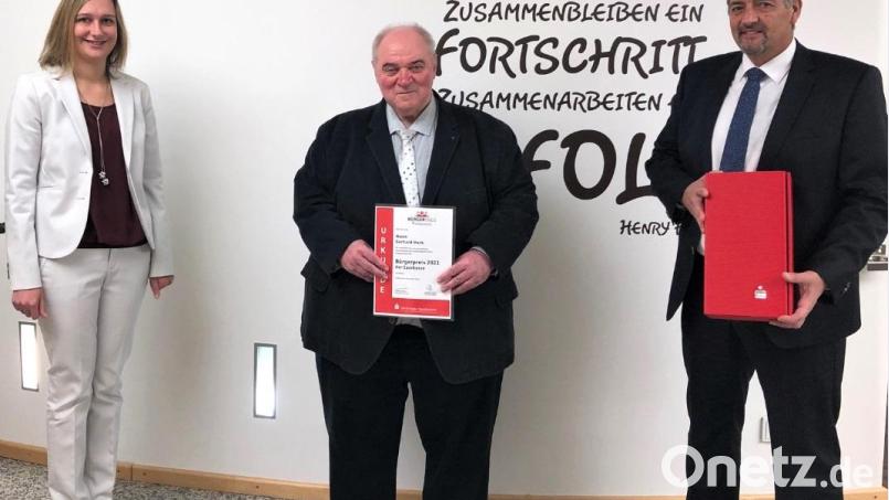 Gerhard Mark (Mitte) nimmt den Sparkassen-Bürgerpreis 2021 aus den Händen von Silvia Lehner von der Sparkasse in Grafenwöhr und Bürgermeister Edgar Knobloch (rechts) entgegen. Bild: Sparkasse/exb
