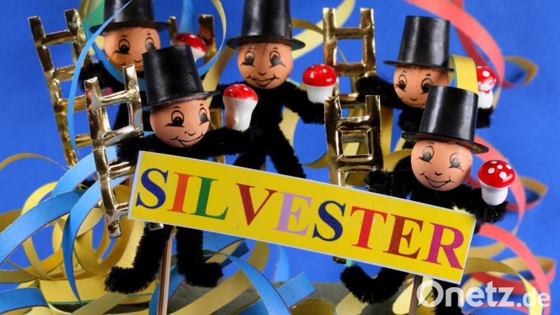 Kleine Schornsteinfeger-Figuren als Glücksbringer für das Neue Jahr posieren vor farbigen Luftschlangen. Symbolbild: Jens Büttner