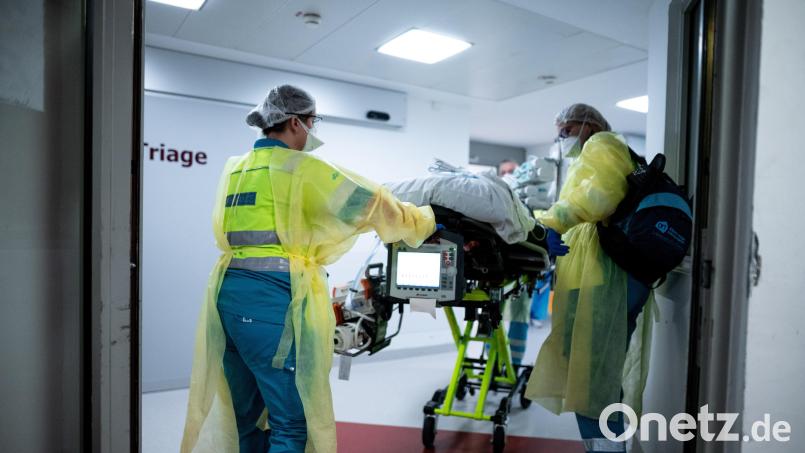 Die Besatzung eines Krankenwagens bringt einen Covid-19-Patienten in ein Krankenhaus. Symbolbild: Fabian Strauch/dpa