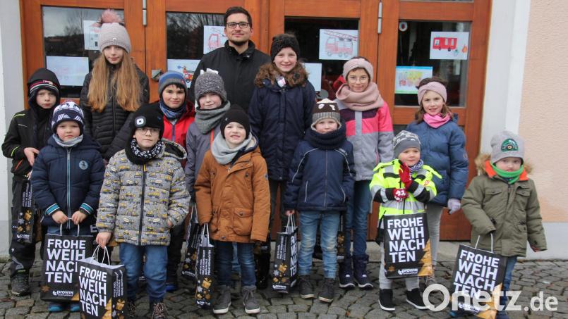 Der Vorsitzende des Feuerwehrvereins, Andreas Weis (Mitte), und die Kinder, die am Malwettbewerb teilgenommen haben. Bild: kro
