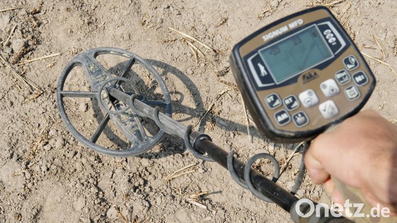 Michael Schmahl zeigt einen Metalldetektor über einem Acker. Symbolbild: Sebastian Willnow