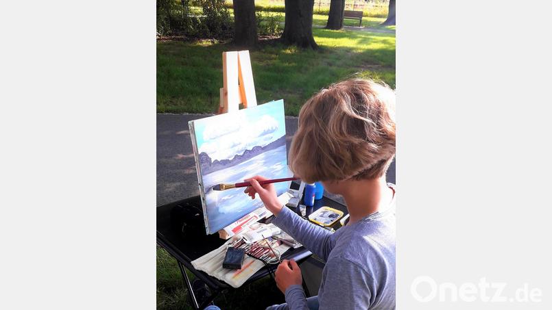 Mit dem Pinsel bringen die Künstler Farbe auf den weißen Hintergrund und somit in den Pressather Stadtpark. Bild: Johannes Janner/Gerti Reynolds/exb