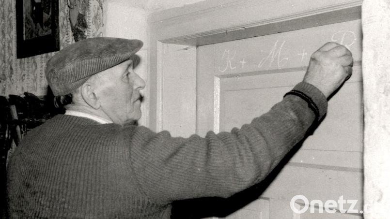 Vor dreißig Jahren (1992) beschriftet der 83-jährige Bauer Anton Hanauer am Vorabend von Heiligdreikönig die Türen seines Hauses in Konatsried. Archivbild: lg