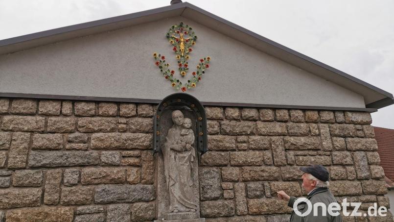 Pfarrer Erwin Bauer bewundert das Meisterwerk von Hobbyschlosser Bruno Lang. Er hat es überaus filigran aus Abfallblech geschaffen. Ein kleines Meisterwerk mit Blüten und Blättern. Bild: gz