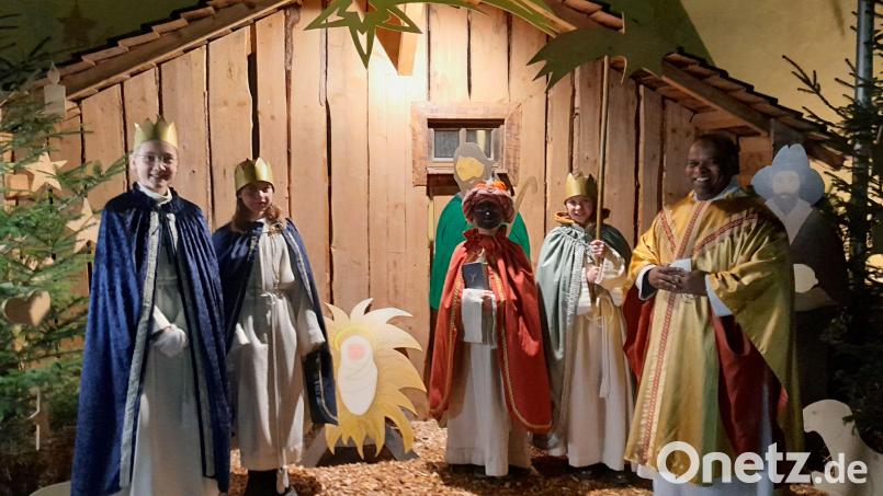 Die Lintacher Sternsinger zusammen mit Pfarrer Moses Gudapati vor der Krippe bei der Pfarrkirche St. Walburga. Bild: jow