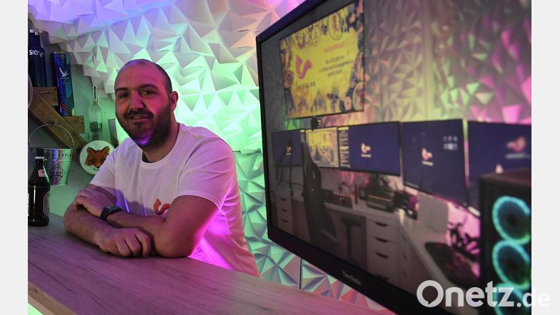 Pascal Thelen lehnt an einem Tresen im Dachgeschoss seiner Wohnung. Auf dem Bildschirm rechts ist sein Arbeitsplatz als Twitch-Streamer zu sehen. Archivbild: Petra Hartl