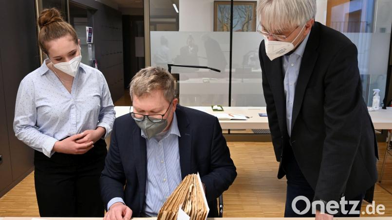 Oberbürgermeister Michael Cerny (Mitte) mit dem Leiter des Stadtarchivs Amberg (rechts) und Auszubildender Franziska Geißler bei der Durchsicht der Witzesammlung von Joachim Kubeng, die zusammen mit seinem weiteren Nachlass im Archiv aufbewahrt wird. Bild: Susanne Schwab, Stadt Amberg/exb