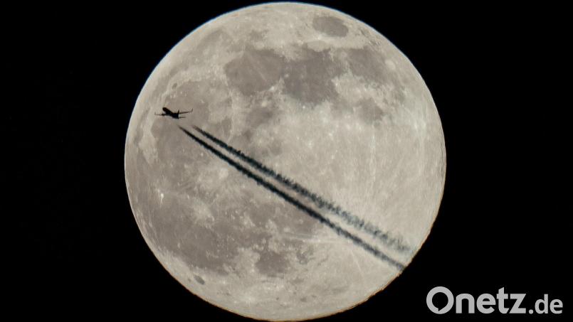 Ein Flugzeug fliegt am Mond vorbei, dem ersten Vollmond des Jahres 2022. Bild: Aaron Chown
