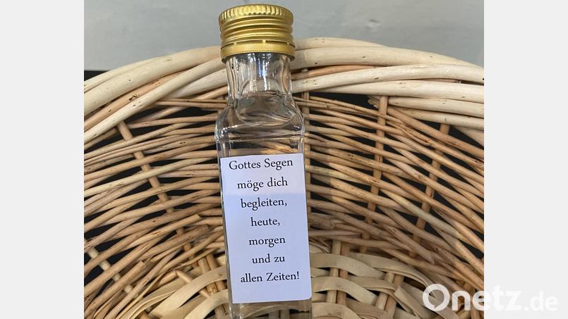 Die Täuflinge erhielten zur Erinnerung ein Fläschchen Weihwasser mit einem Segensspruch. Bild: Markus Scharnagl/exb