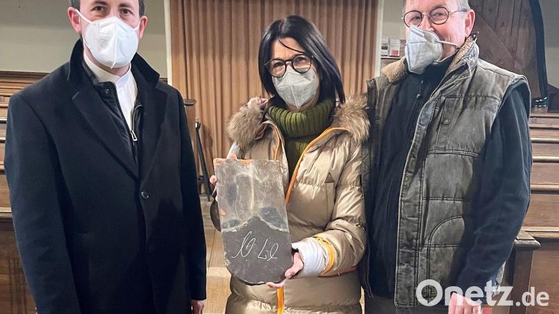 Ein Ehepaar aus Roth in Mittelfranken (rechts) hat den von Ministerpräsident Markus Söder signierten Ziegel ersteigert. Darüber freute sich Pfarrer Stefan Fischer (links). Bild: Heidi Kurz