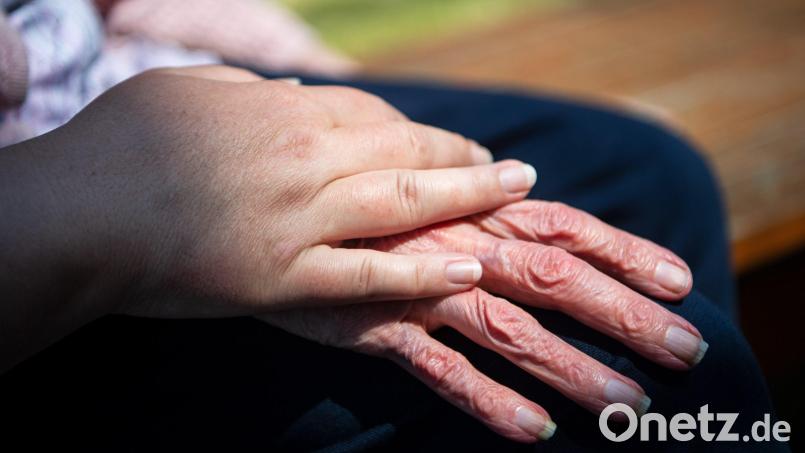 Die Hand einer Pflegefachkraft liegt auf der Hand einer Bewohnerin eines Seniorenheims. Symbolbild: Sina Schuldt