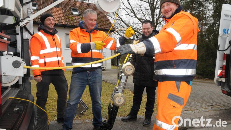 Bauhofleiter Stephan Glossner (links) und Bürgermeister Sebastian Hartl (2. von rechts) beobachten das Herablassen der Kamera in den Kanal. Die Kamera muss oftmals den Verhältnissen im Untergrund angepasst werden. Bild: bey