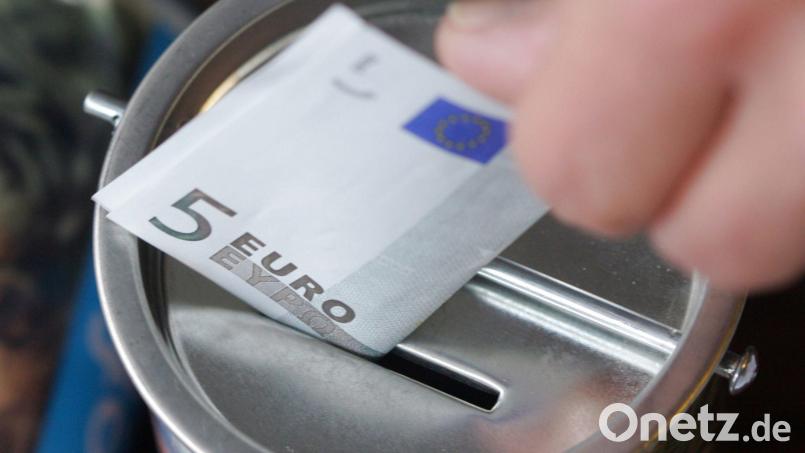 Ein Fünf-Euro-Schein wird in eine Spendendose gesteckt. Symbolbild: Bernd Thissen/dpa