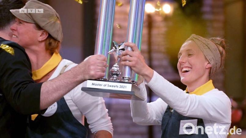 Carolin Brunner (rechts) und Tina Herzog (links), die gerade Juror René Frank umarmt, nahmen nach dem Sieg in der ersten Staffel der RTL-Show &quot;Master of Seweets&quot; überglücklich den Pokal entgegen. Bild: RTL/exb