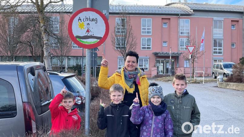 Schilderaktion in Nabburg: Familienbeauftragte Ines Renner mit Kindern aus der OGTS, die die Schilder gestaltet haben. Bild: Marko Pammer/exb