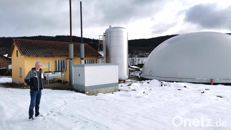Keine Angst vor hohen Heizkosten: Michael Sorgenfrei vor der Biogasanlage (rechts) und dem Blockheizkraftwerk (links). Bild: Portner