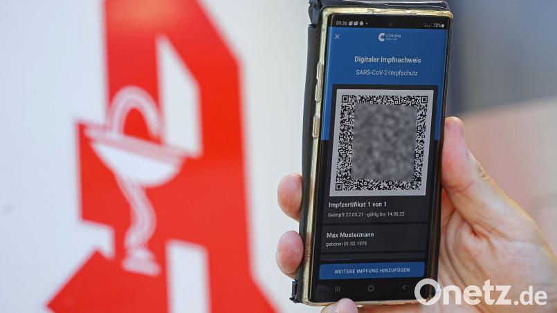 Der digitale Impfnachweis ist vor dem Apotheken-Logo auf einem Smartphone zu sehen. Symbolbild: Oliver Berg/dpa