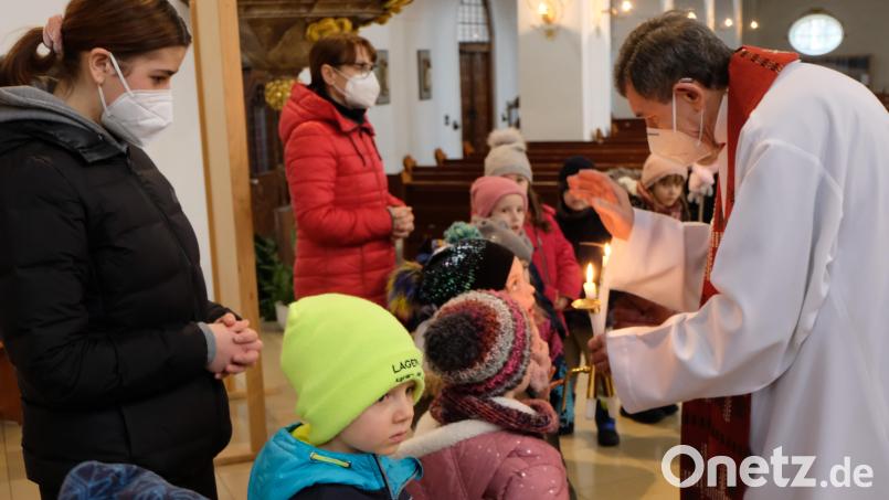 Pfarrer Max Früchtl erteilt den Mädchen und Buben den Blasiussegen. Bild: le