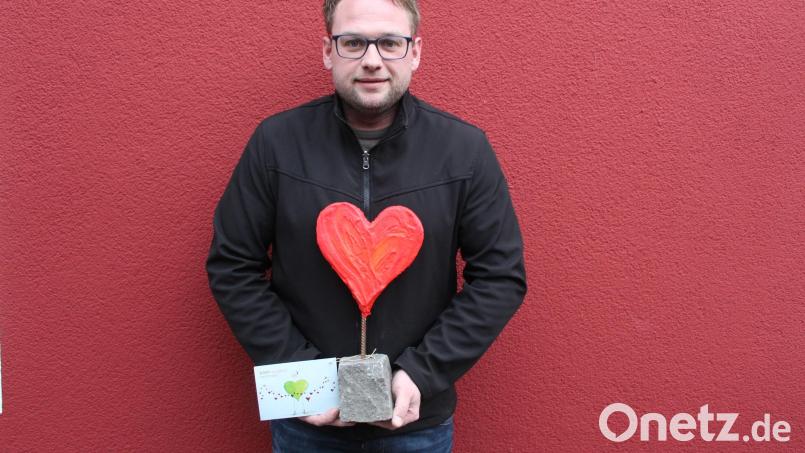 Johannes Bauer erhielt stellvertretend für alle Spender ein bedeutungsvolles Präsent: einen Pflasterstein aus dem Katastrophengebiet, auf dem ein rotes Herz steht. Bild: soj