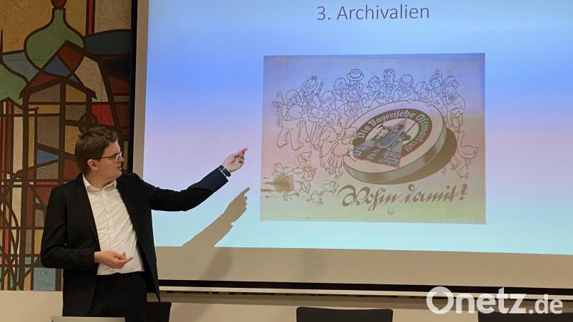 David Austermann stellt den Zuhörern die "Verschlussmarke" vor. Mit diesem Emblem wollte das NS-Regime für den Tourismus in der Region werben. Bild: ero