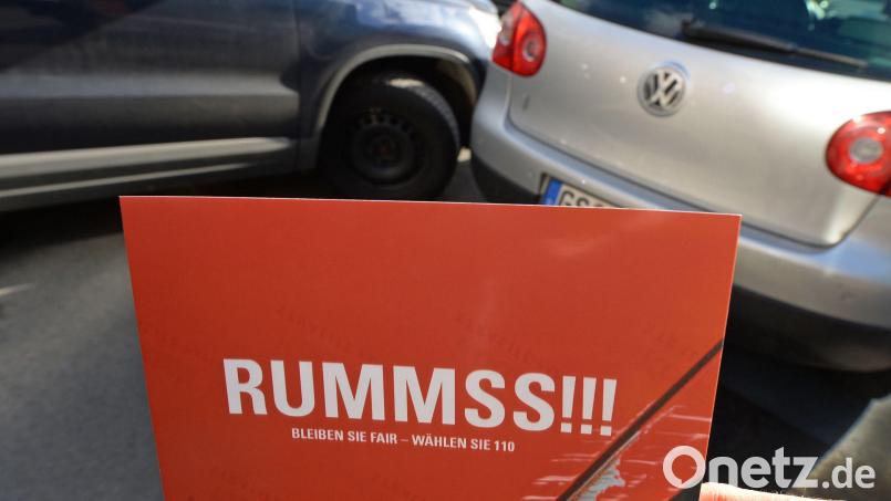 „Bleiben Sie fair – wählen Sie 110“, wenn es „Rummss!!!“ macht, steht auf einer Postkarte, die vor eine gestellte Unfallsituation mit zwei Personenwagen gehalten wird. Für einen Mann aus dem Landkreis Tirschenreuth kein Thema. Nachdem er ein Auto angefahren hatte, machte er sich aus dem Staub. Jetzt stand er vor Gericht. Symbolbild: Holger Hollemann/dpa