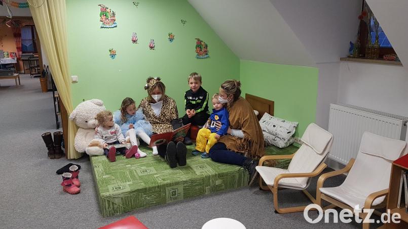 Aufmerksam lauschten die Kinder der Geschichte vom Grolltroll, die ihnen Märchentante Birgit Gerlach-Kneißl vorlas. Unterstützt wurde sie von einer Mama. Bild: gi