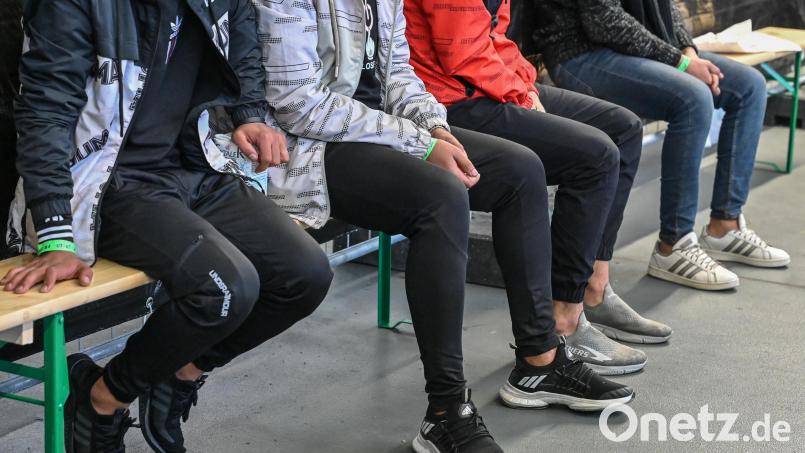 Migranten sitzen bei der Bundespolizei auf Bierbänken und warten. Symbolbild: Patrick Pleul