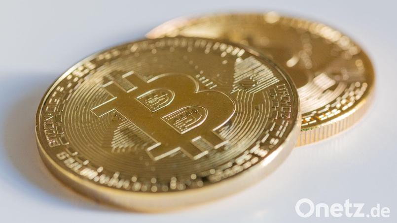 Zwei Bitcoin-Münzen liegen auf einem Tisch. Kryptowährungen locken mit großen Renditen, die Polizei mahnt zur Vorsicht. Symbolbild: Fernando Gutierrez-Juarez/dpa
