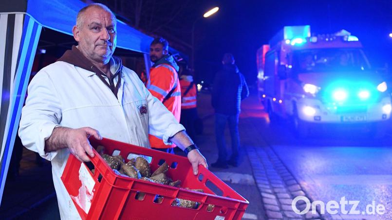 Metzger Ingo Ruber hält eine Kiste mit Semmeln, die er für die Einsatzkräfte bereitgestellt hat. Foto: Lennart Preiss/dpa Bild: Lennart Preiss