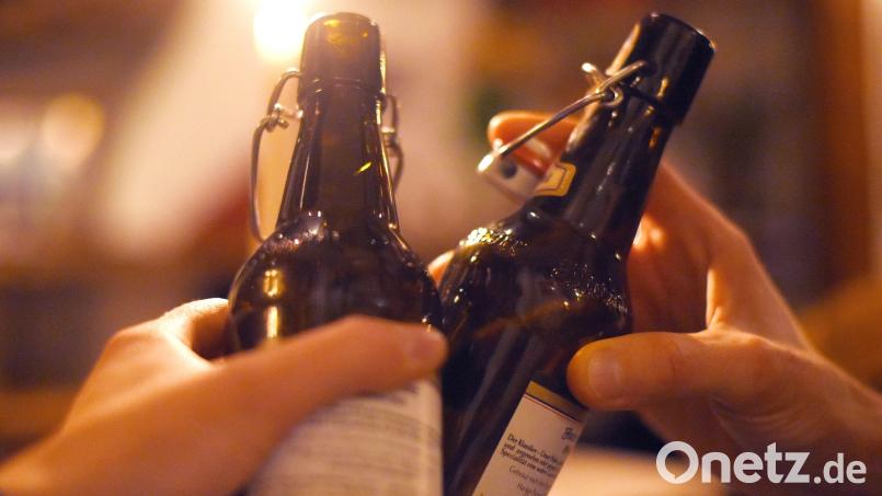 Zwei Gäste stoßen mit Bier in der Flasche an. Symbolbild: Angelika Warmuth/dpa