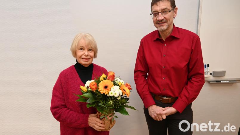 Gisela Schubert unterrichtet seit 50 Jahren Englisch an der Volkshochschule Amberg. VHS-Leiter Reiner Volkert gratuliert mit einem Blumenstrauß. Bild: Thomas Graml, Stadt Amberg/exb