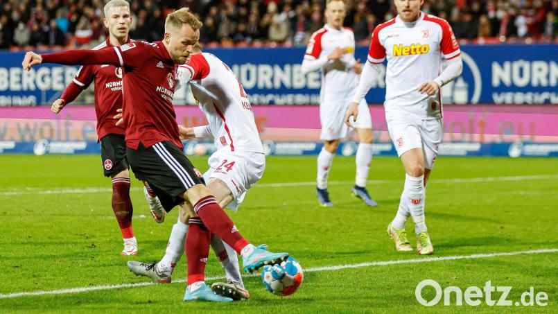 Pascal Köpke (links) windet sich im Regensburgs Verteidiger Scott Kennedy, doch sein Abschluss verfehlte in dieser Szene noch das Jahn-Tor. Wenig später netzte der Club-Angreifer aber per Kopf zum 1:0 ein. Bild: Daniel Löb/dpa